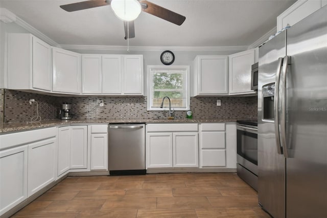 kitchen featuring sink, tasteful backsplash, ornamental molding, appliances with stainless steel finishes, and white cabinets