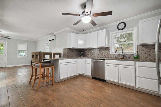 kitchen featuring a wall mounted air conditioner, dishwasher, sink, and white cabinets