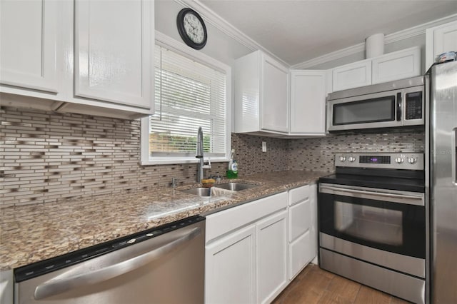 kitchen featuring sink, stainless steel appliances, tasteful backsplash, light stone counters, and white cabinets