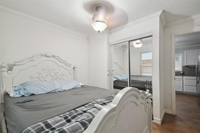 bedroom with ornamental molding, dark wood-type flooring, ceiling fan, and a closet