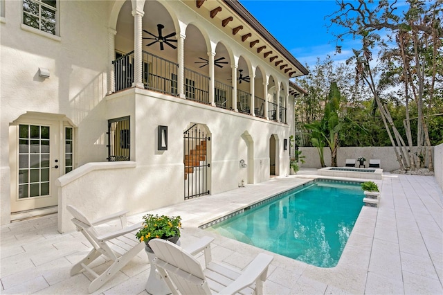 rear view of property featuring a fenced in pool, stucco siding, a patio, and ceiling fan