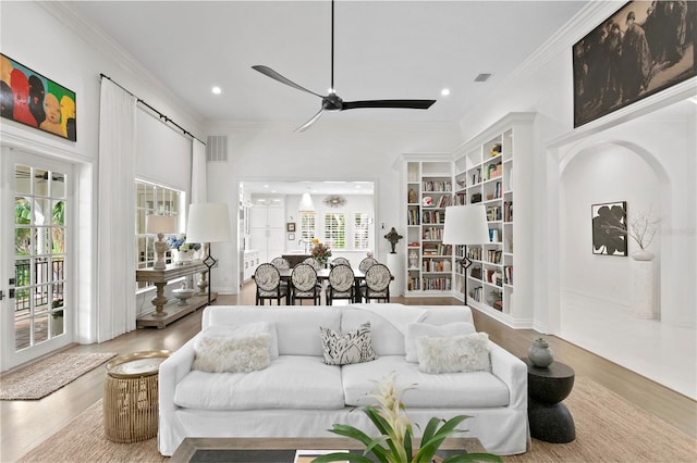 living room with crown molding, wood-type flooring, plenty of natural light, and ceiling fan