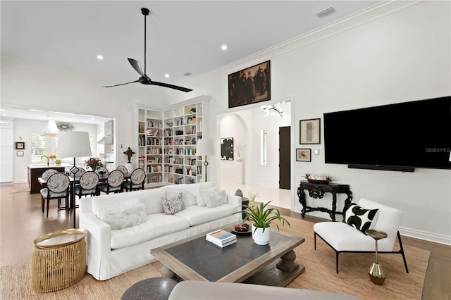 living room with ornamental molding, hardwood / wood-style floors, and ceiling fan