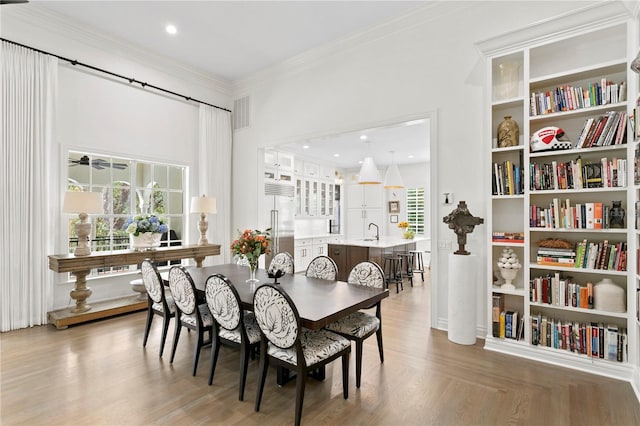 dining room with sink, ornamental molding, a wealth of natural light, and hardwood / wood-style floors