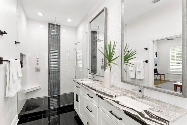 bathroom featuring a tile shower, ornamental molding, vanity, and tile patterned floors