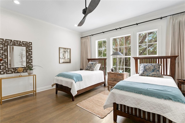 bedroom with crown molding, wood-type flooring, and ceiling fan