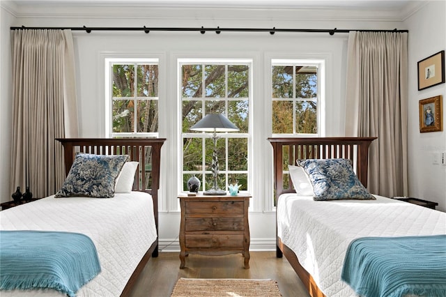 bedroom with dark wood-type flooring and crown molding