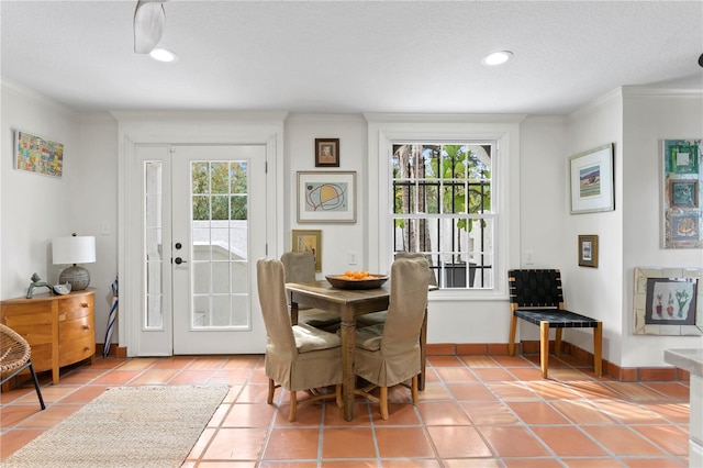 dining space with ornamental molding, plenty of natural light, and tile patterned flooring