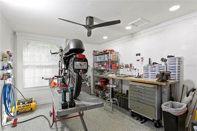 workout room featuring a textured ceiling, a workshop area, and ceiling fan