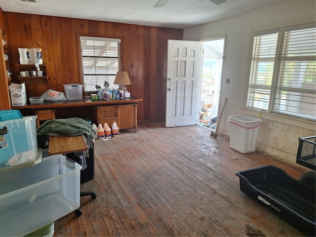 home office with hardwood / wood-style floors, wooden walls, plenty of natural light, and ceiling fan