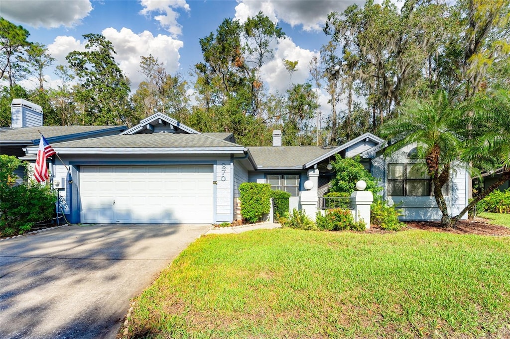 ranch-style house with a garage and a front lawn