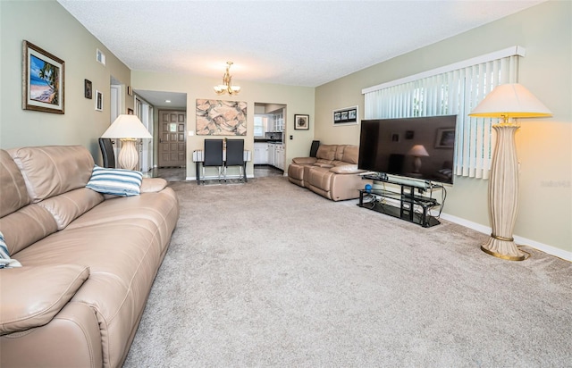 carpeted living room with an inviting chandelier and a textured ceiling