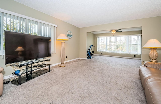 living room featuring ceiling fan, a textured ceiling, and carpet floors