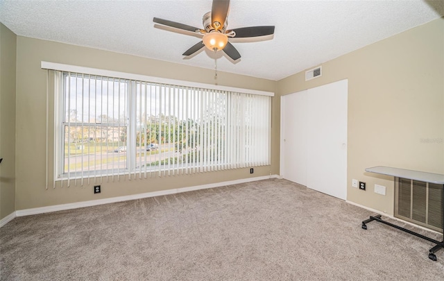 unfurnished room featuring carpet floors, a textured ceiling, and ceiling fan