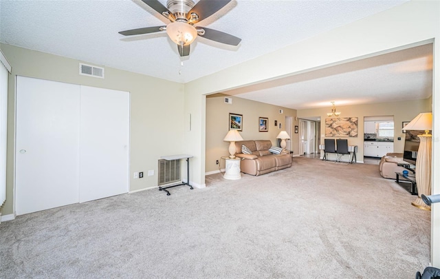 carpeted living room featuring a textured ceiling and ceiling fan