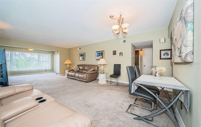 carpeted living room with a textured ceiling and an inviting chandelier