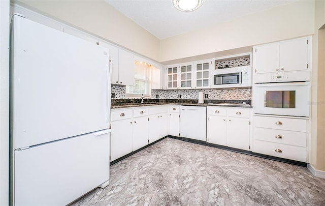 kitchen featuring decorative backsplash, white cabinetry, sink, and white appliances