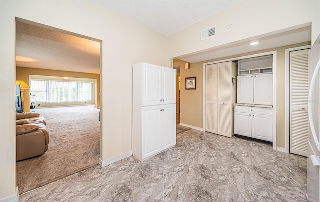 unfurnished bedroom featuring a textured ceiling and light colored carpet