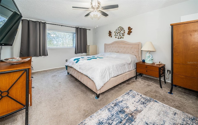 carpeted bedroom featuring ceiling fan and a textured ceiling