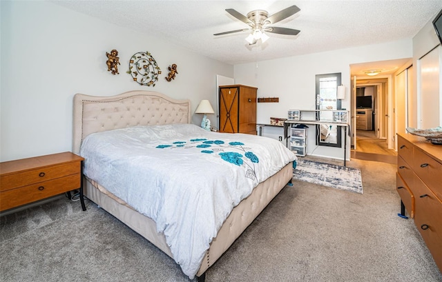 carpeted bedroom featuring a textured ceiling and ceiling fan