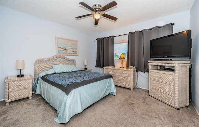 carpeted bedroom featuring a textured ceiling and ceiling fan