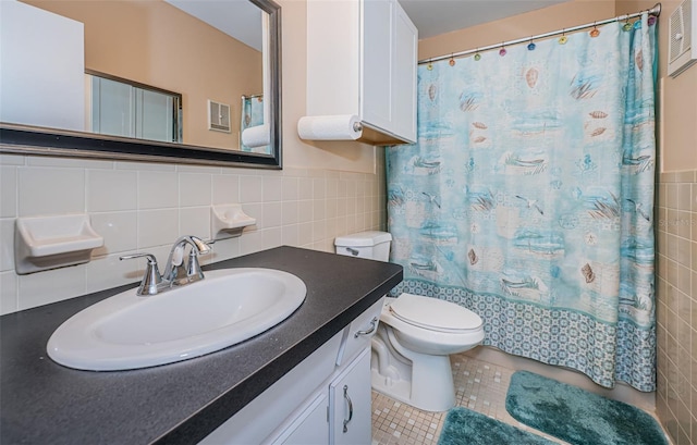 bathroom featuring vanity, toilet, tile patterned floors, and tile walls