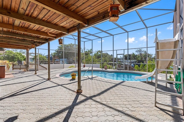 view of swimming pool featuring a water slide, a lanai, and a patio