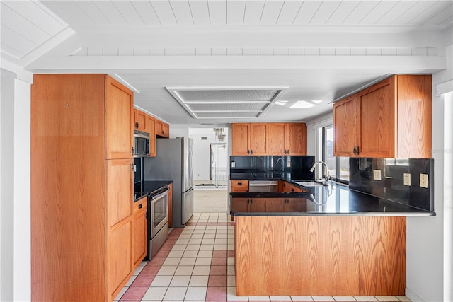 kitchen with sink, light tile patterned floors, kitchen peninsula, stainless steel appliances, and decorative backsplash