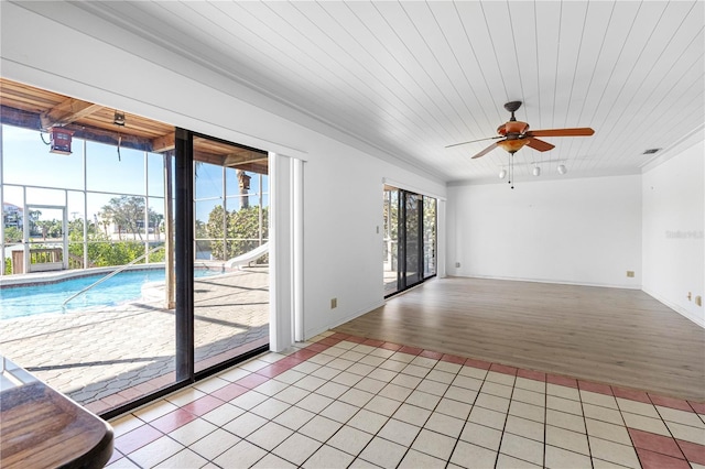 spare room with a ceiling fan, visible vents, and light tile patterned floors