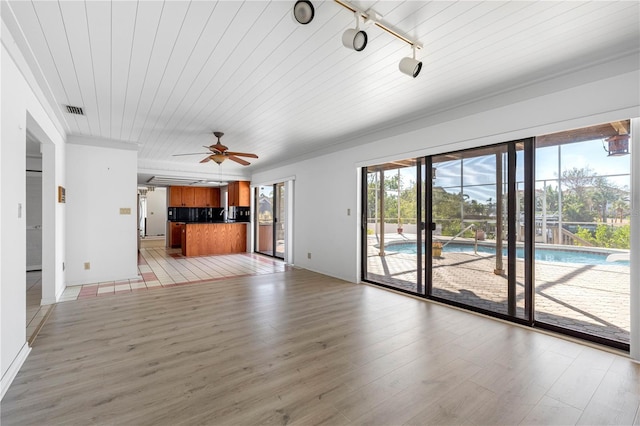 unfurnished living room featuring light hardwood / wood-style flooring, plenty of natural light, rail lighting, and ceiling fan