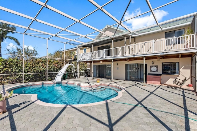 view of pool with a patio, a water slide, and a lanai