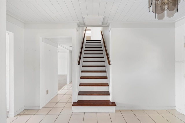 stairway with ornamental molding, tile patterned flooring, wood ceiling, and baseboards