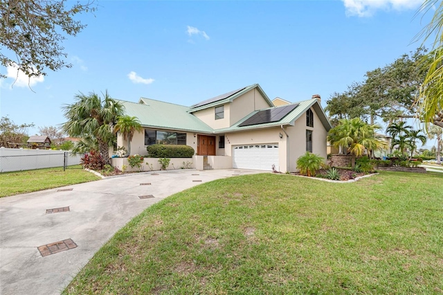 view of front of home with a garage, a front yard, and solar panels