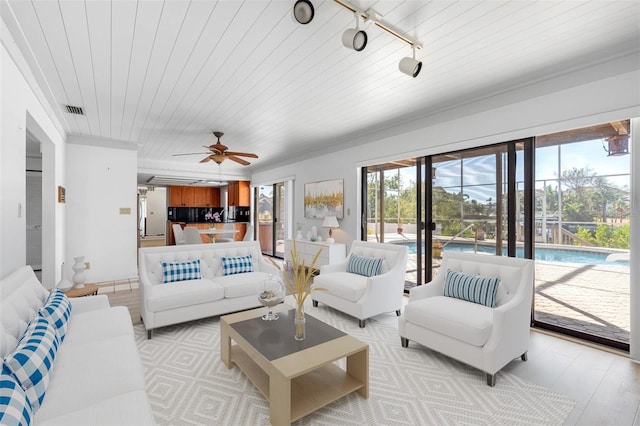 living room with wood ceiling, a wealth of natural light, visible vents, and track lighting