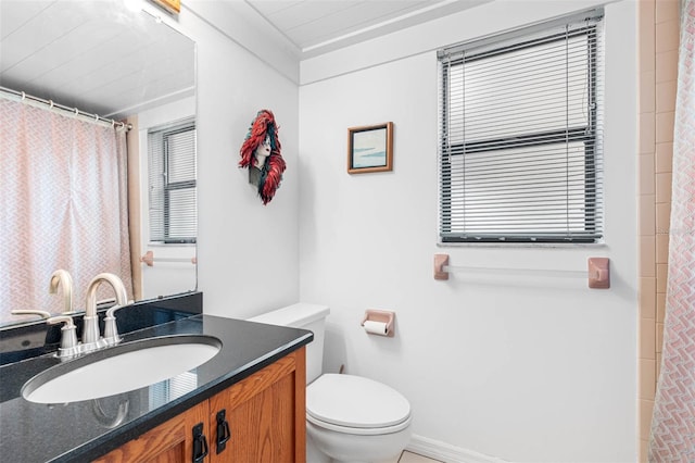 full bath featuring toilet, a healthy amount of sunlight, and vanity