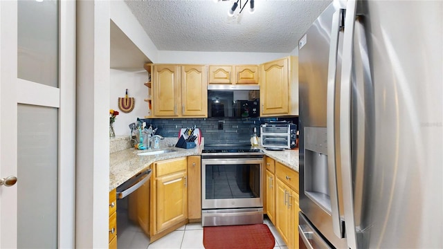 kitchen with tasteful backsplash, light tile patterned floors, appliances with stainless steel finishes, a textured ceiling, and light stone countertops