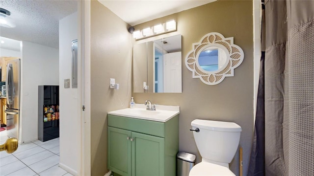 bathroom with vanity, a textured ceiling, toilet, and tile patterned flooring