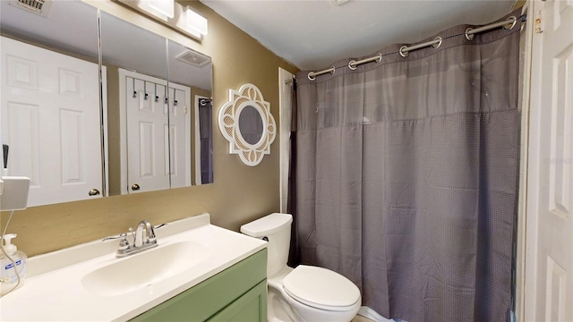 bathroom with toilet, curtained shower, and vanity