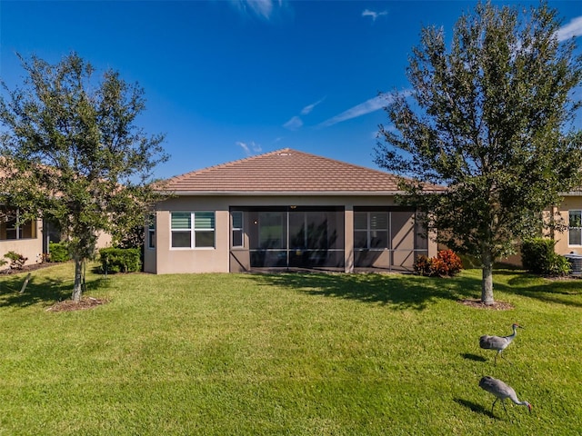 back of property featuring a yard and a sunroom