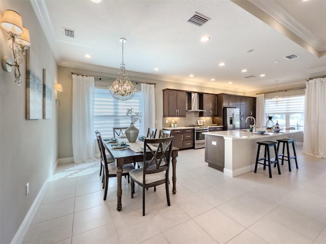 tiled dining space with sink and crown molding