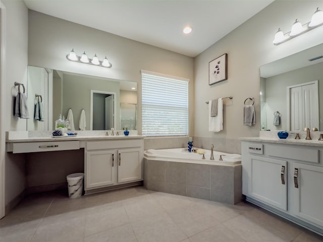 bathroom with tiled bath, tile patterned flooring, and vanity