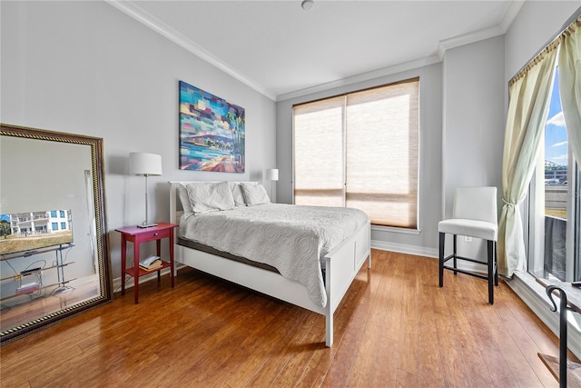 bedroom featuring wood-type flooring, multiple windows, and crown molding