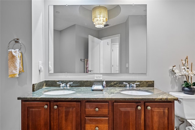 bathroom with vanity, a chandelier, and toilet