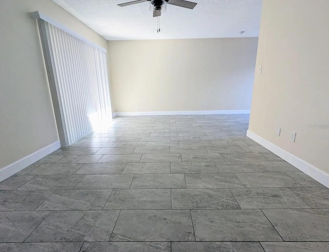 unfurnished room with ceiling fan and a textured ceiling