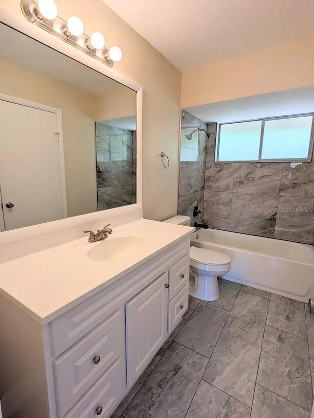 full bathroom featuring toilet, tiled shower / bath combo, and vanity