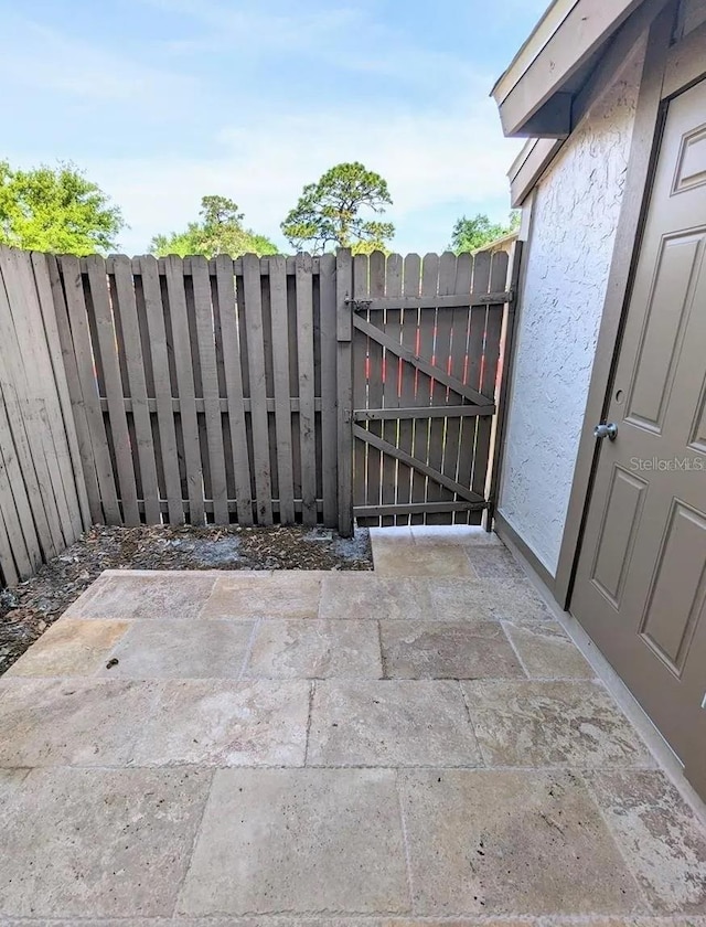 view of gate with a patio