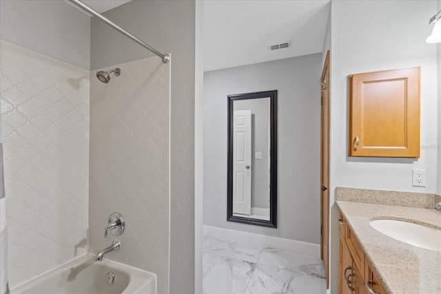 bathroom with tiled shower / bath and vanity