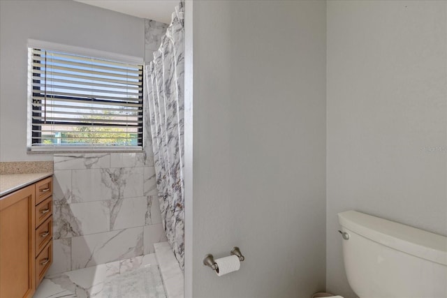 bathroom featuring toilet, walk in shower, and vanity