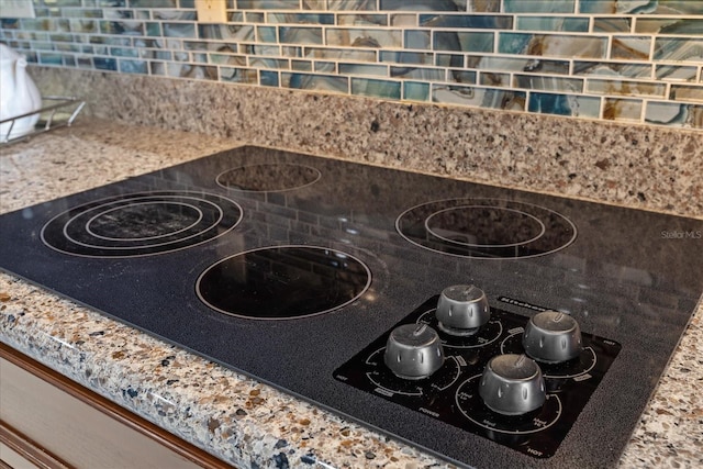 interior details with decorative backsplash and black electric cooktop