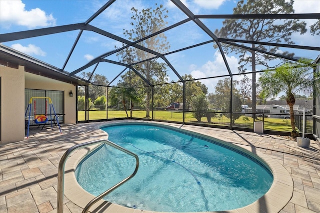 view of swimming pool with a patio, a lanai, and a yard